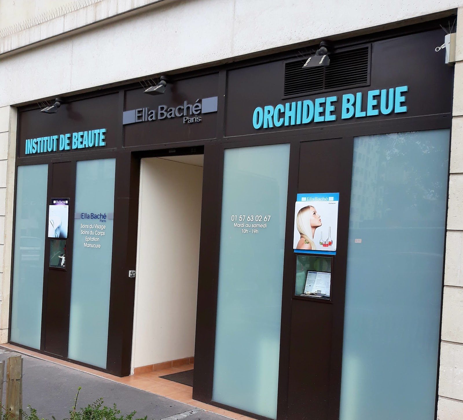 La devanture de l’institut Orchidée Bleue au 180 avenue de Paris : montants bruns, vitres turquoise dépolies et porte ouverte sur un couloir clair.